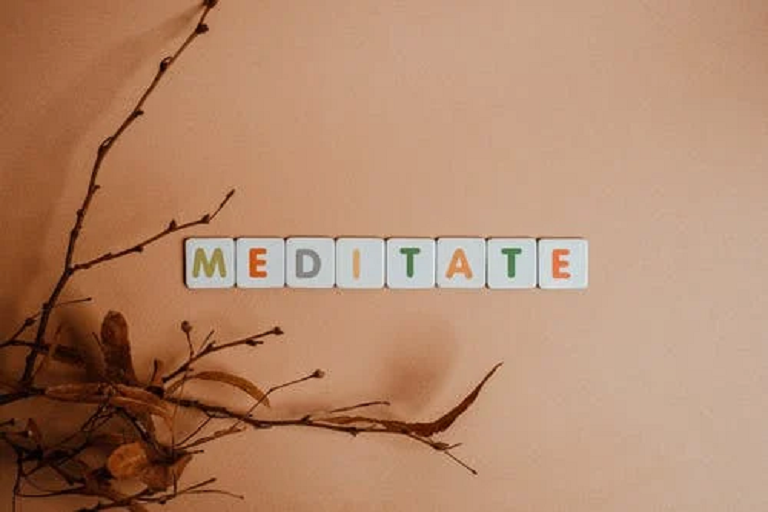 Dry leaves and alphabet blocks spelling meditate